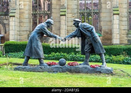 “All together now” statue by Andy Edwards, commemorating the Christmas Day 1914 truce, stands in grounds of St Luke's Church in Liverpool, England, UK