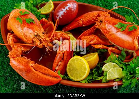 Restaurant food for american football game partry. Red lobsters on plate with ball. Stock Photo