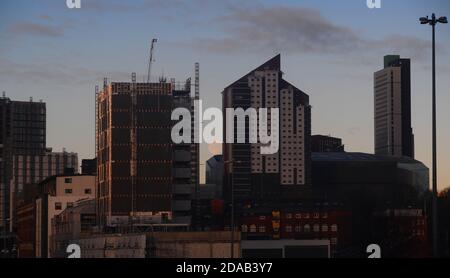 moon rising between office blocks in leeds city centre yorkshire united kingdom Stock Photo