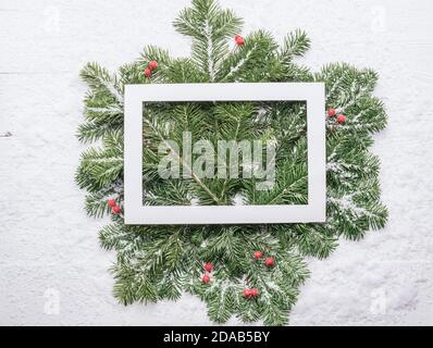 Fluffy green spruce branches white frame wooden background. Christmas concept Stock Photo
