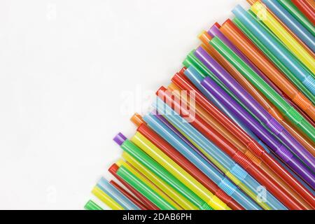 Multicoloured plastic straws on a white background with copy space. Celebration and party background Stock Photo
