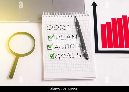 Plan and goals for 2021. Action text in notepad. Worker office desk. Business motivation, ideas for inspiration Stock Photo