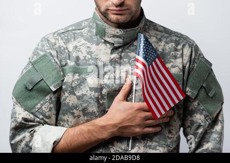 cropped view of patriotic military man in uniform holding american flag isolated on white Stock Photo