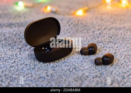 Wireless black headphones isolated on gray plush Stock Photo