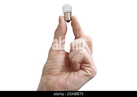 A man's hand holds a small light bulb in his fingers. Isolate on a white background. Concept of an idea or inspiration. Stock Photo