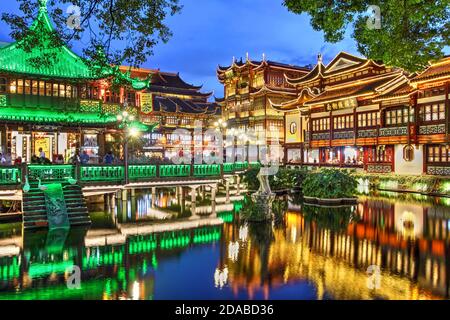 Night scene in the famous Yu Garden and Bazaar, featuring restaurants and shops as well as the famous Huxinting Teahouse facing the small central pond Stock Photo