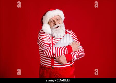 Portrait of his he nice handsome cheerful cheery bearded Santa father holding in hands hugging laptop North Pole December wintertime isolated bright