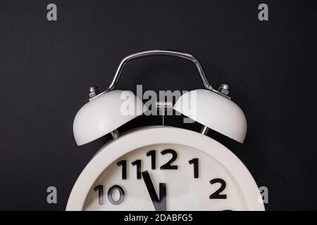Black retro alarm clock on dark background. Stock Photo