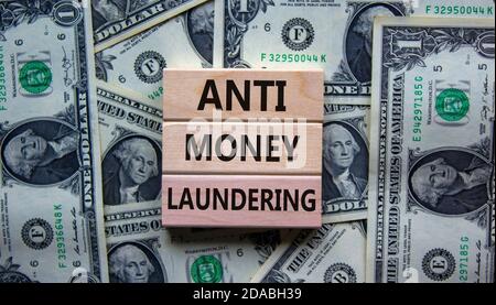 Wood blocks with words 'Antimoney laundering' on a beautiful background from dollar bills. Business concept, copy space. Stock Photo