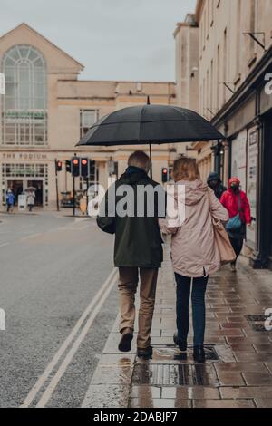 Bath, UK - October 04, 2020: Rear view of a senior couple walking on a street in Bath, the largest city in the county of Somerset known for and named Stock Photo