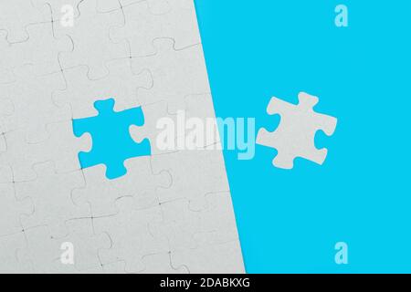 The correct missing puzzle piece on a light blue background in a top view Stock Photo