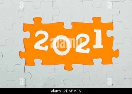 2021 year greeting with puzzle pieces on a orange background Stock Photo