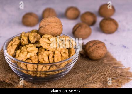 Shelled walnuts in a transparent glass bowl. Close-up. Stock Photo