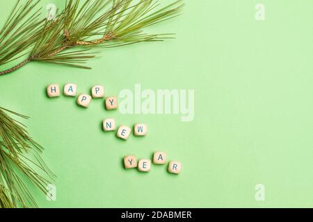 Happy new year greeting made with wooden letter cubes on a green background Stock Photo