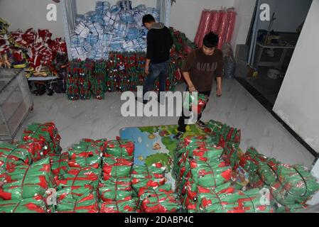 (201111) -- HEZE, Nov. 11, 2020 (Xinhua) -- Online clothes store owners Sun Zhiguo (L) and Sun Lei arrange Christmas costumes for sales to Thailand in Sunzhuang Village in Caoxian County of Heze City, east China's Shandong Province, Nov. 9, 2020. Sunzhuang Village thrives on e-commerce business. Among some 760 households in the village, more than 560 run online clothes stores on Taobao.com, Alibaba's main e-commerce site. The village's sales volume of costumes exceeded 200 million yuan (about 30.22 million U.S. dollars) in 2019. (Xinhua/Wang Kai) Stock Photo