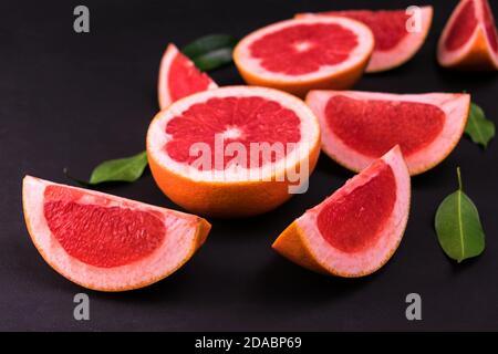 Sliced ​​grapefruit on a black background. Flat lay. Stock Photo