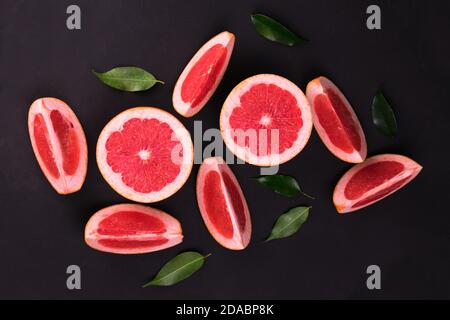 Sliced ​​grapefruit on a black background. Flat lay. Stock Photo