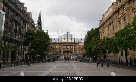 Paris, France - 09/07/2019: Front view of historic Palais de Justice ('palace of justice') with tourists walking by on a pedestrian zone. Stock Photo