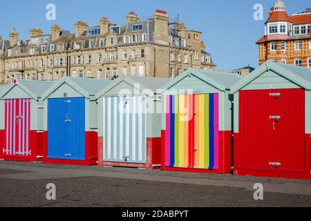 Colourful beach huts and pride beach hut along the promenade of Hove seafront, Brighton & Hove, East Sussex, UK Stock Photo