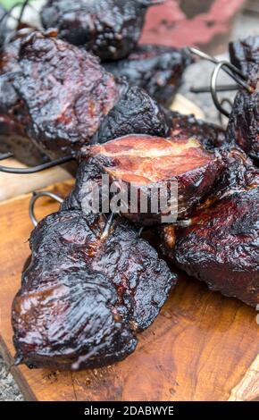 Smoking meat in the smokehouse. Traditional method of smoking meat in smoke. Food without chemicals and preservatives. Stock Photo