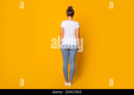 Back rear spine behind view photo of charming pretty youth woman stand good look wear gumshoes millennial style clothes isolated over shine color Stock Photo