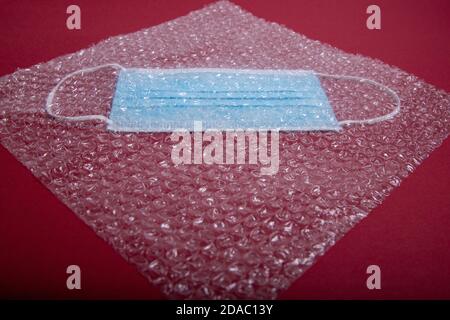 blue mouthguard under a plastic bubble wrap on a red background, perspective view Stock Photo