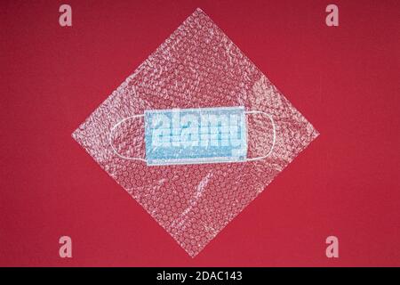 blue mouthguard under a plastic bubble wrap on a red background, shot from above Stock Photo