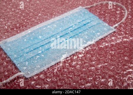 blue mouthguard under a plastic bubble wrap on a red background, perspective view Stock Photo