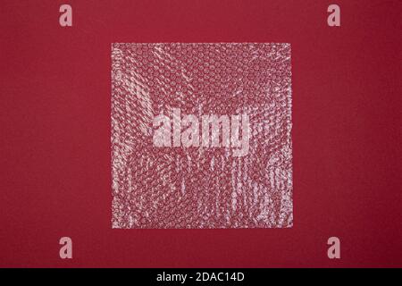plastic bubble wrap on a red background, view from above Stock Photo