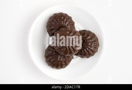 Dessert chocolate marshmallow is in a white plate on a light background. Stock Photo