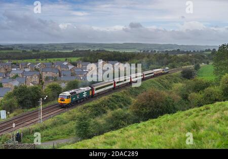 Class 47 locomotive 47593 passing a mechanical semaphore signal at Hellifield with a 'staycation express' charter train Stock Photo