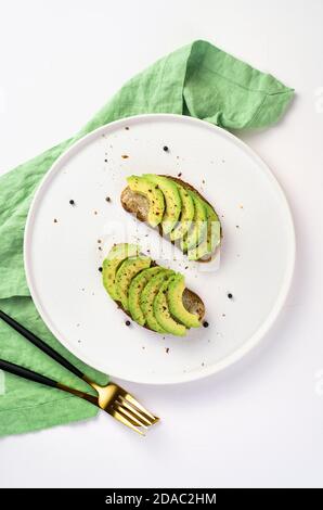 Sandwiches with avocado slices on rye bread on a light background. Stock Photo