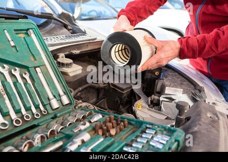 New cartridge of air filter, male hands installing maintenance item, close-up view Stock Photo