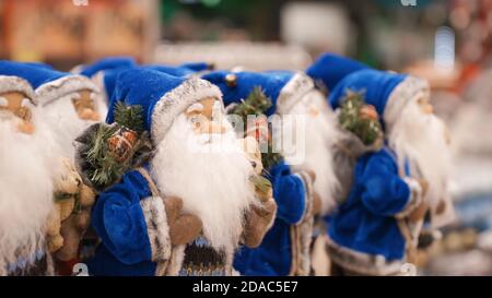 Many blue Santa Claus Xmas decoration figures in shop Stock Photo