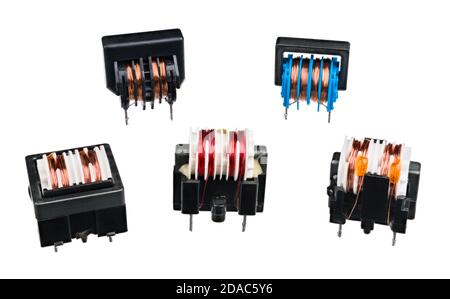 Set of various transformers with coil and black core isolated on white background. Electronic device for electric energy transfer between two circuits. Stock Photo