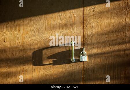 Shiny stainless steel Abloy padlock on closed brown wooden door , Finland Stock Photo