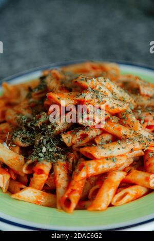 White macaroni with tomato, chilli, oregano, cheese and spices Stock Photo