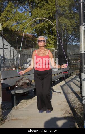 70 year old woman stays in good shape jump roping in the park in Brooklyn,  New York Stock Photo - Alamy