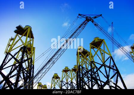 Wind turbine fabrication and cranes at Smulders Howdon on Tyne yard against deep blue sky Stock Photo