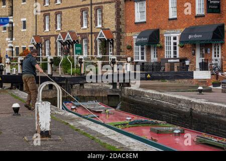 man tying up narrow boat entering a lock on the grand union canal at stoke bruerne in northamptonshire, uk Stock Photo
