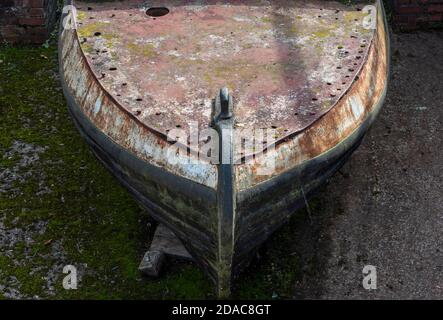 the bows of a derelict rusty corroded old narrow boat at stoke bruerne in northamptonshire, uk Stock Photo
