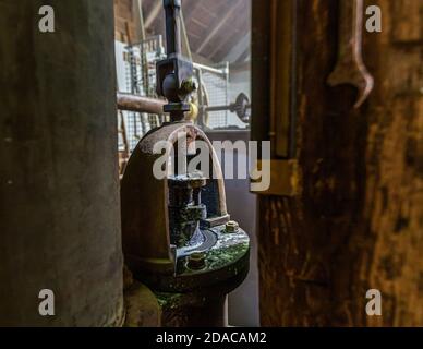 The pump at the community brewery in Falkenberg, Upper Palatinate, Germany, is powered by a reliable mechanical drive. The village blacksmith can still repair it himself if necessary. A spanner hangs within easy reach on the wooden roof structure next to the old component. Zoigl, an amber-coloured, slightly cloudy beer with an alcohol content of 4.9 per cent, is part of Bavaria’s intangible cultural heritage. Stock Photo