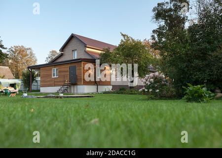 Low country house with back yard, green lawn, nobody Stock Photo