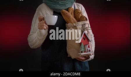 Woman's hands holding cup of coffee and Shopping Bag with Bread for holliday New Year or Christmas Stock Photo