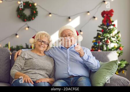 Happy elderly couple congratulating family with New Year holidays online during videocall at home Stock Photo