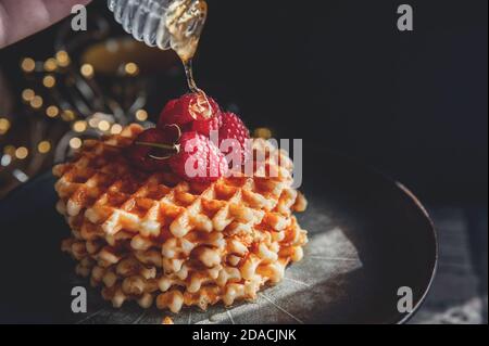 Viennese, Belgian Golden soft waffles with honey on a beautiful plate. Copy space. Low key Stock Photo