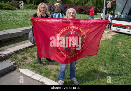 Belgrade, Serbia, May 4, 2017: An elderly lady showing the flag of the Communist Party during the Yugoslav president Josip Broz Tito death anniversary Stock Photo