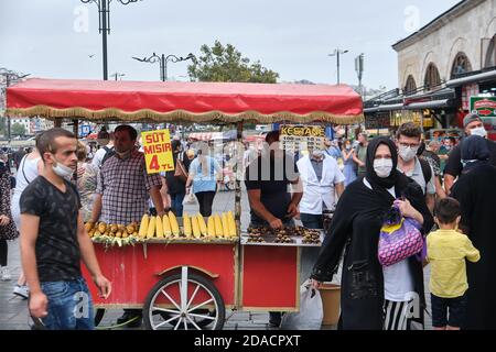 Toasted corn on the cob and roasted chestnuts mobile stall in a busy Eminonu Square filled with local people, Istanbul, Turkey Stock Photo