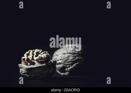 Two walnuts and walnut shells on a black background, close up ,macro photography Stock Photo