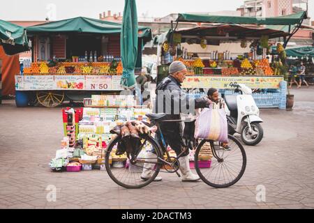 Marrakech, Morocco - APRIL 26 2019: citizen walking with a bicycle in the middle of Medina in the daylight Stock Photo